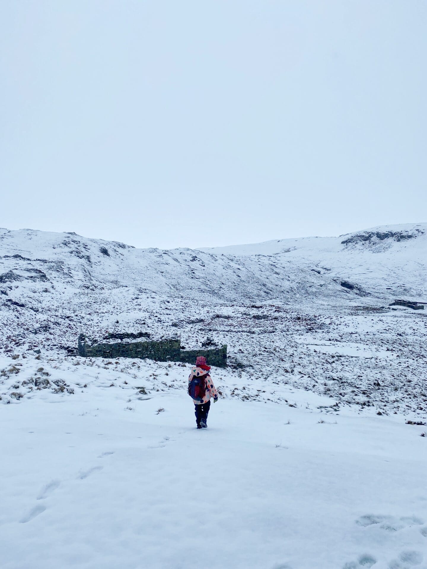 Child on way to ruins of a Croft building in the snow