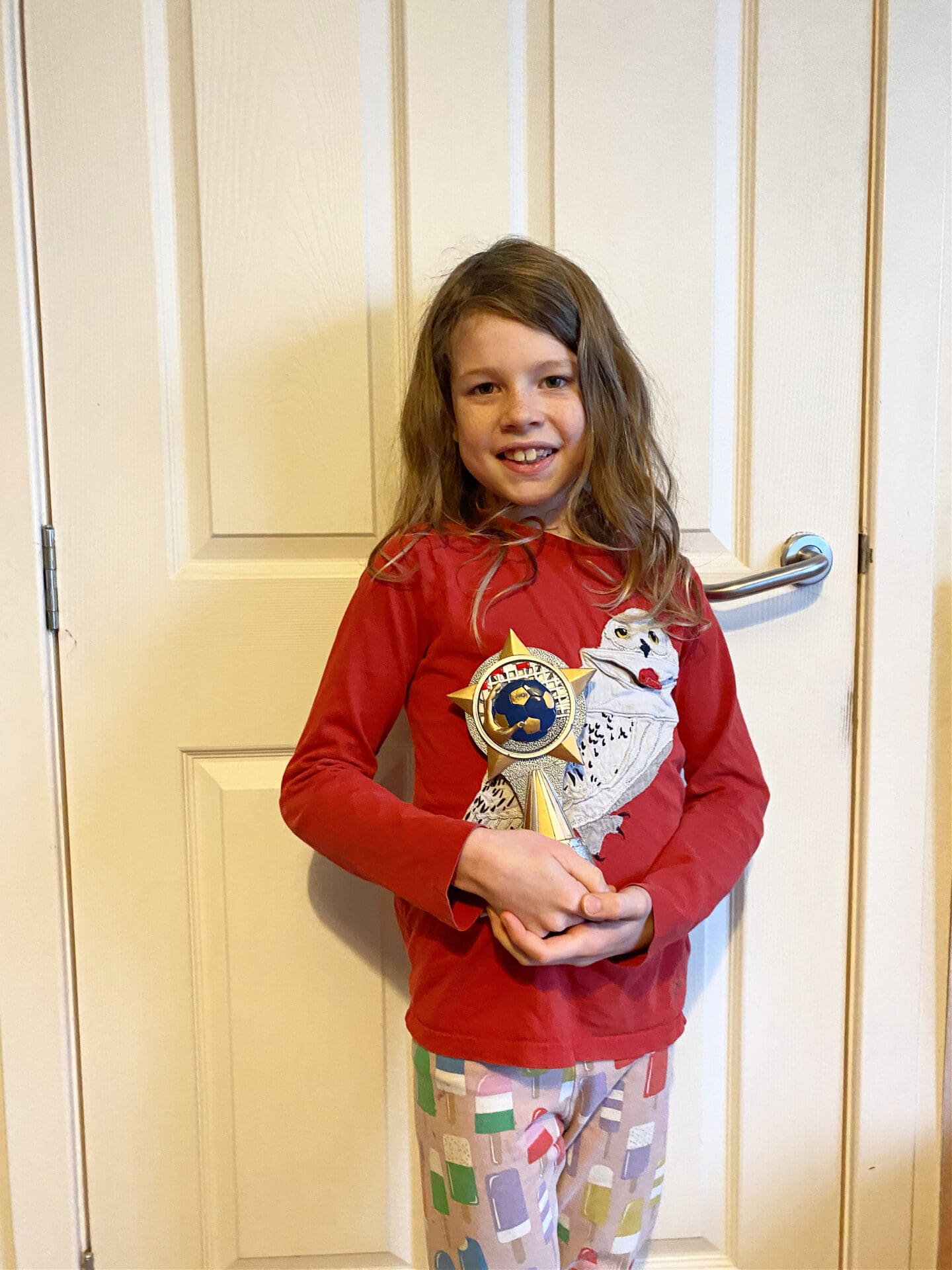 Child with dodgeball trophy