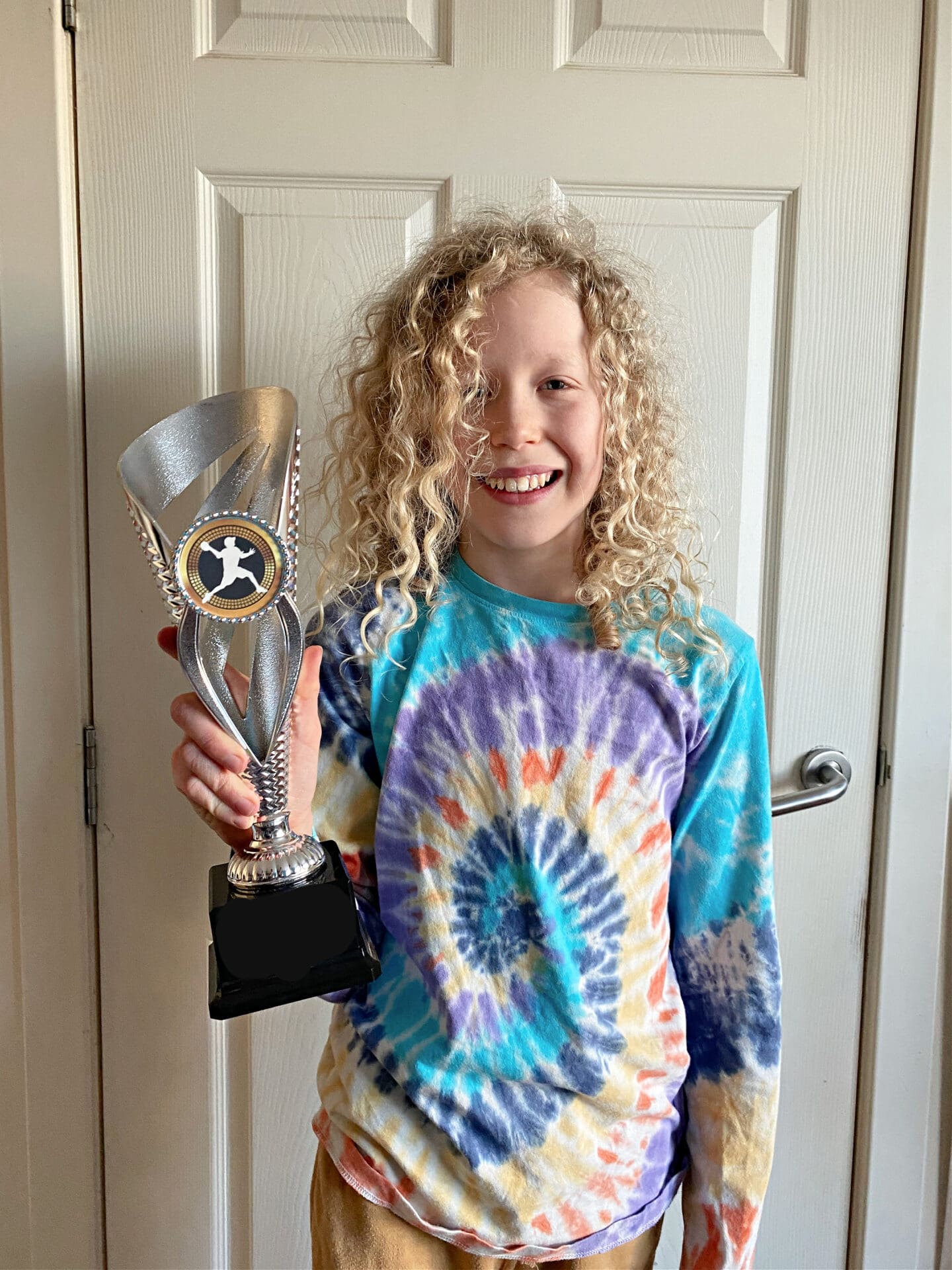 Child with dodgeball trophy