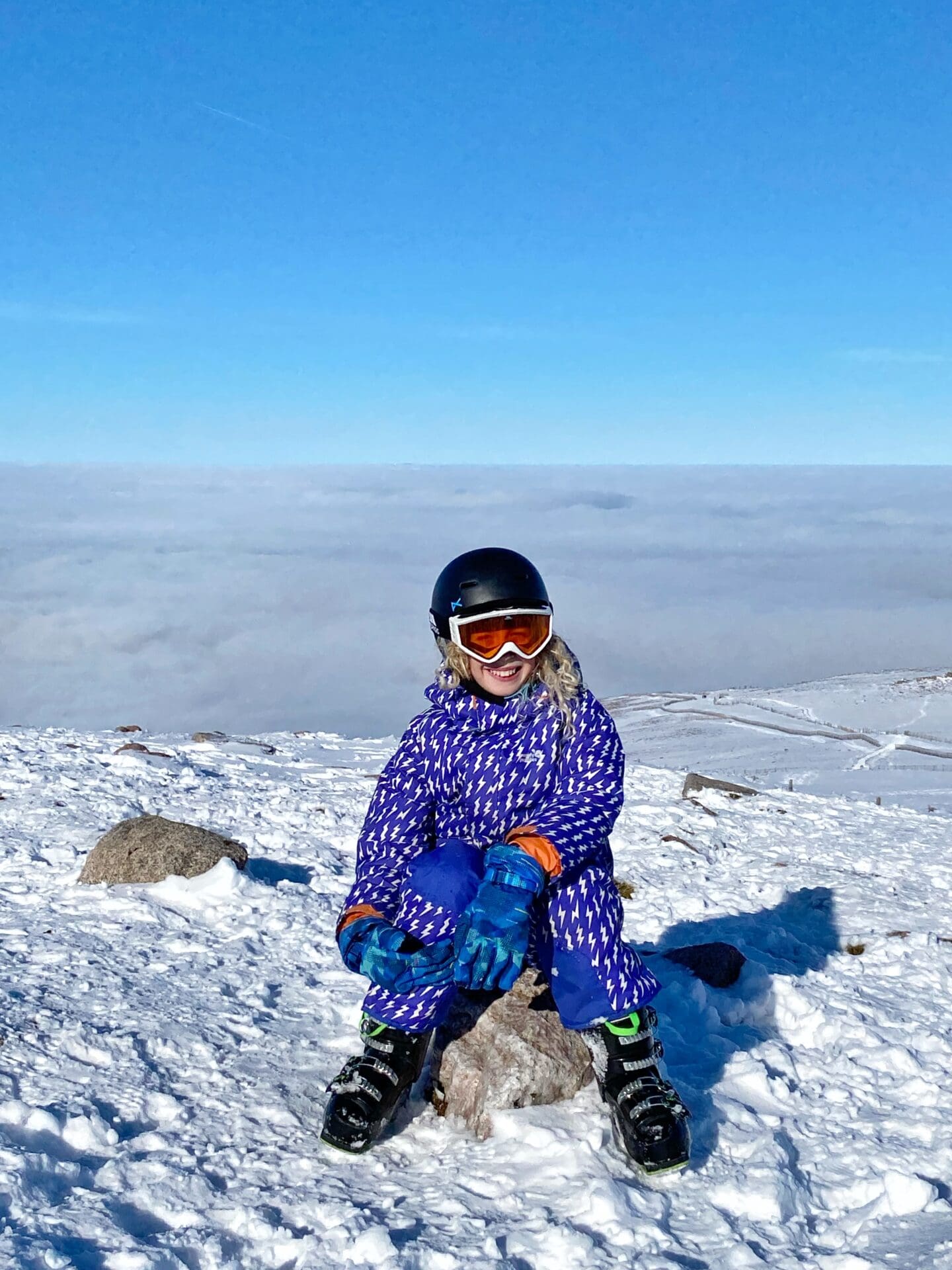 Child sitting on Cairngorm mountain UK