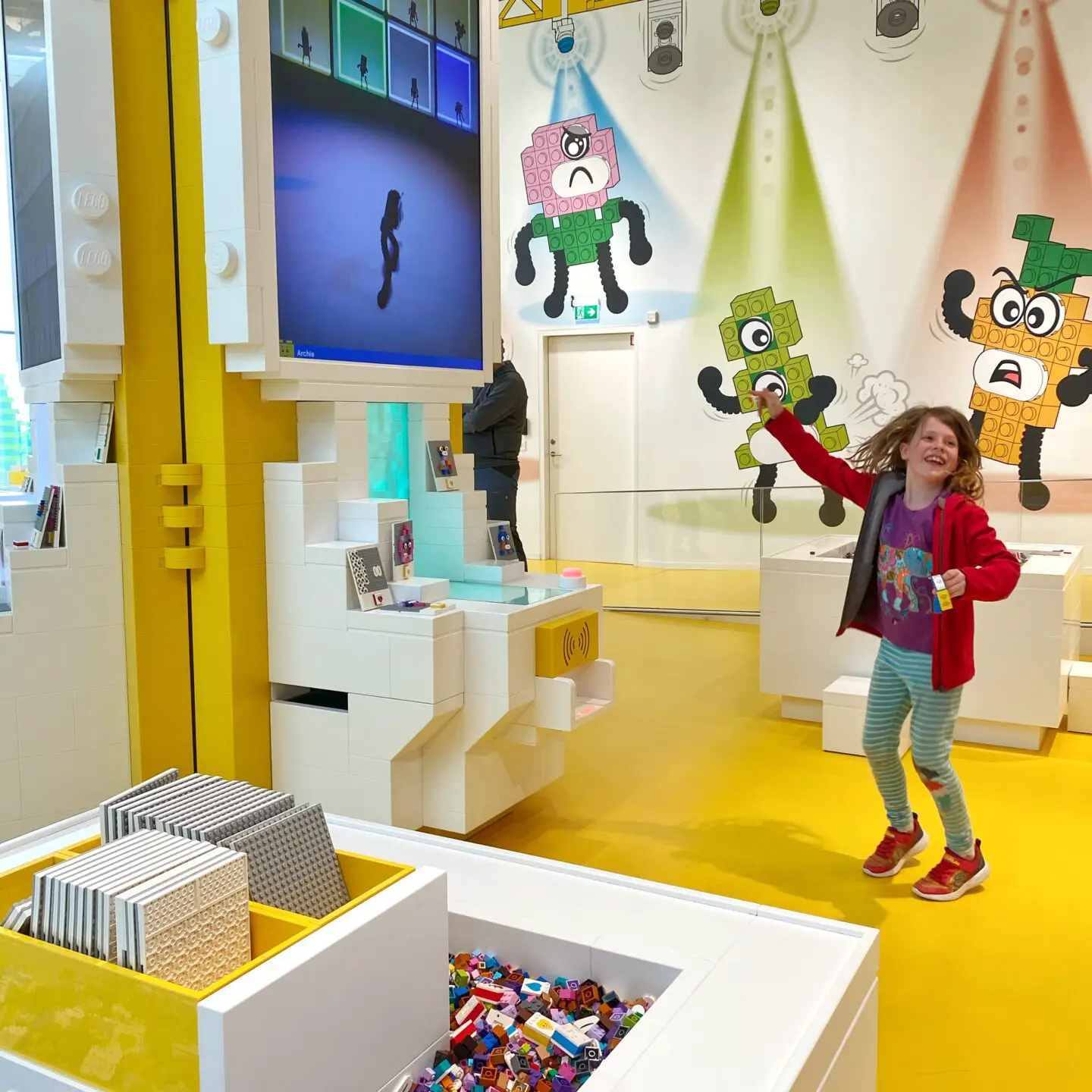 Child dancing with a Lego creation at Lego House