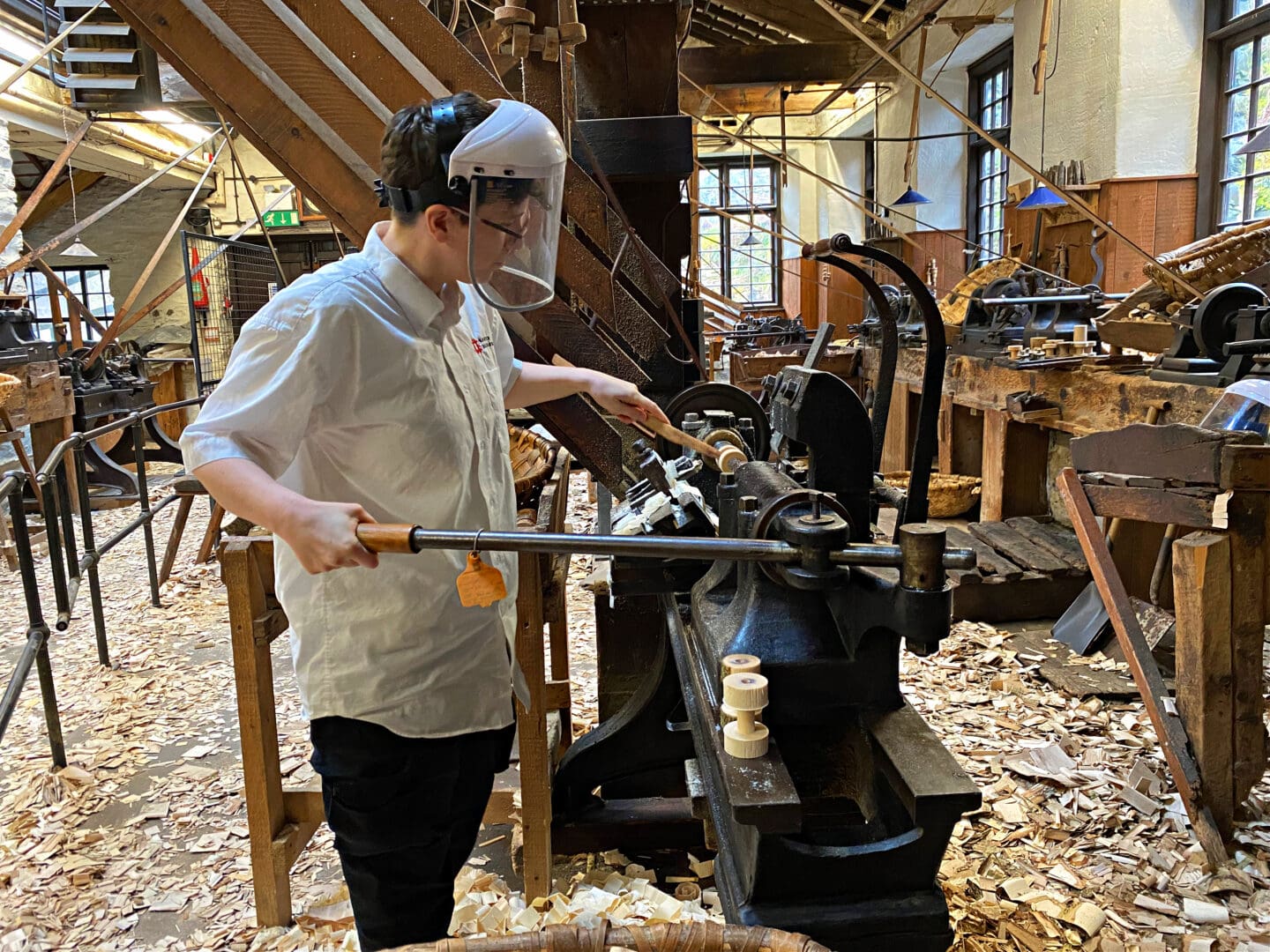 Person working machinery at Bobbin mill Cumbria
