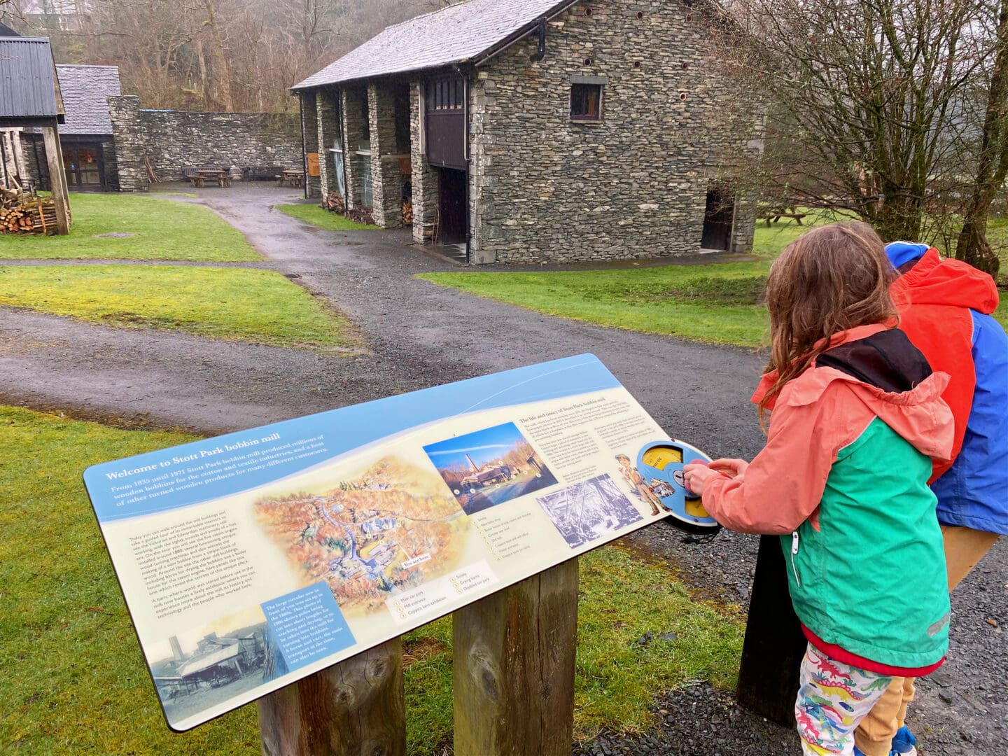 Child looking at sign at bobbin mill, Cumbria