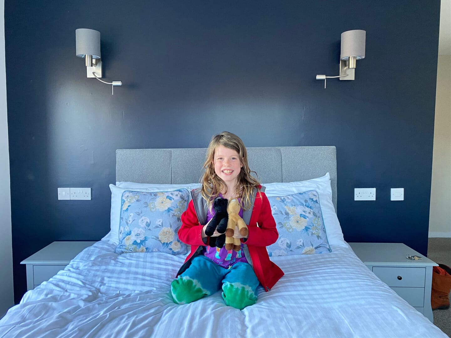 Child on bed with soft toys