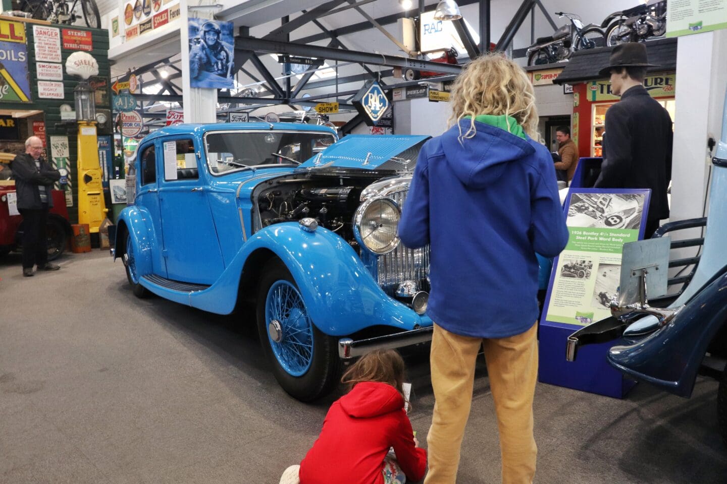 Children looking at a vintage car in museum