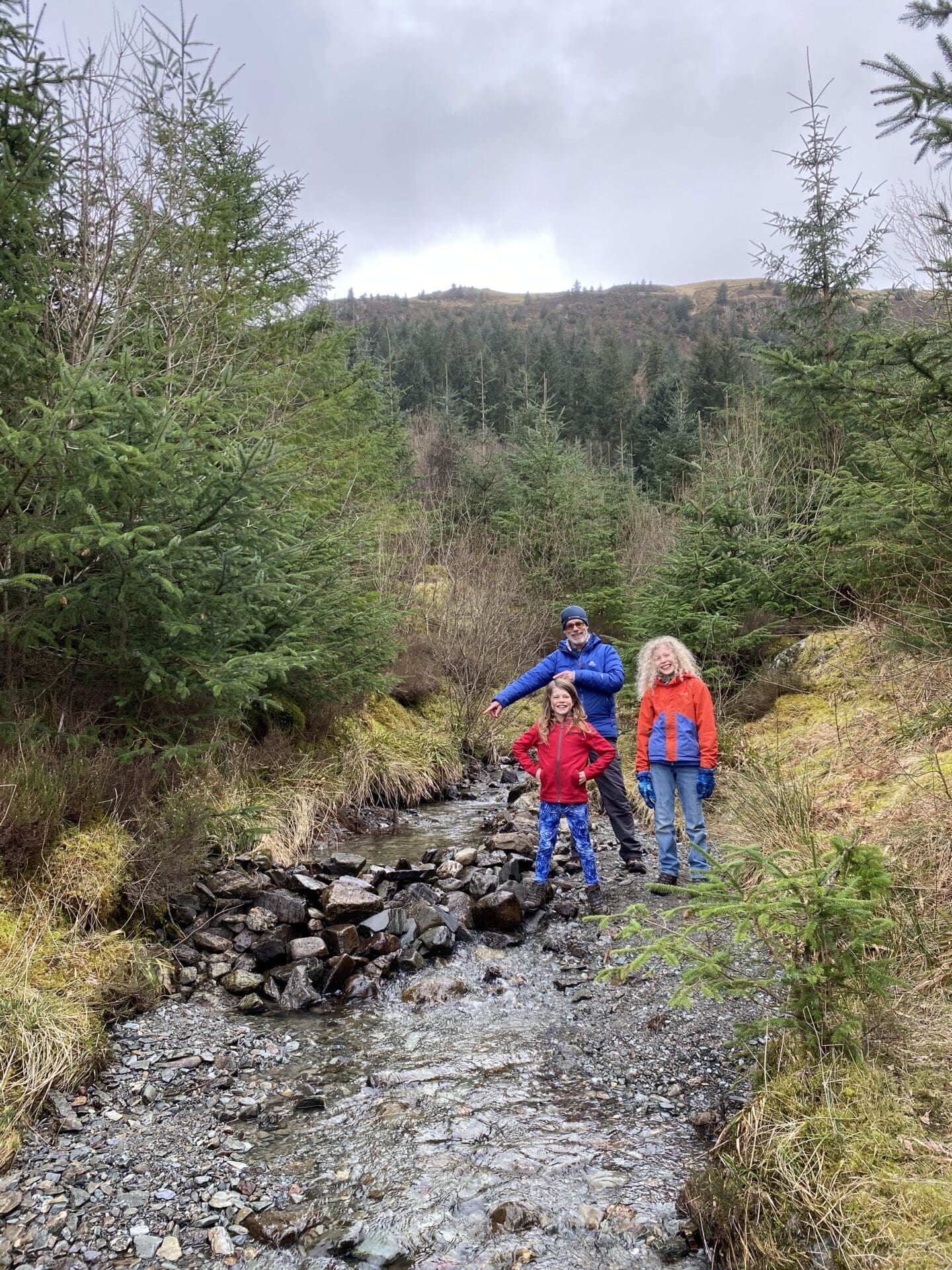 Children beside dam with grandfather