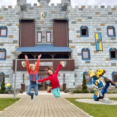 Children jumping in front of wizard castle billund