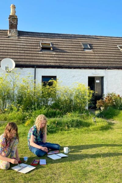 Children painting outside in the cottage garden