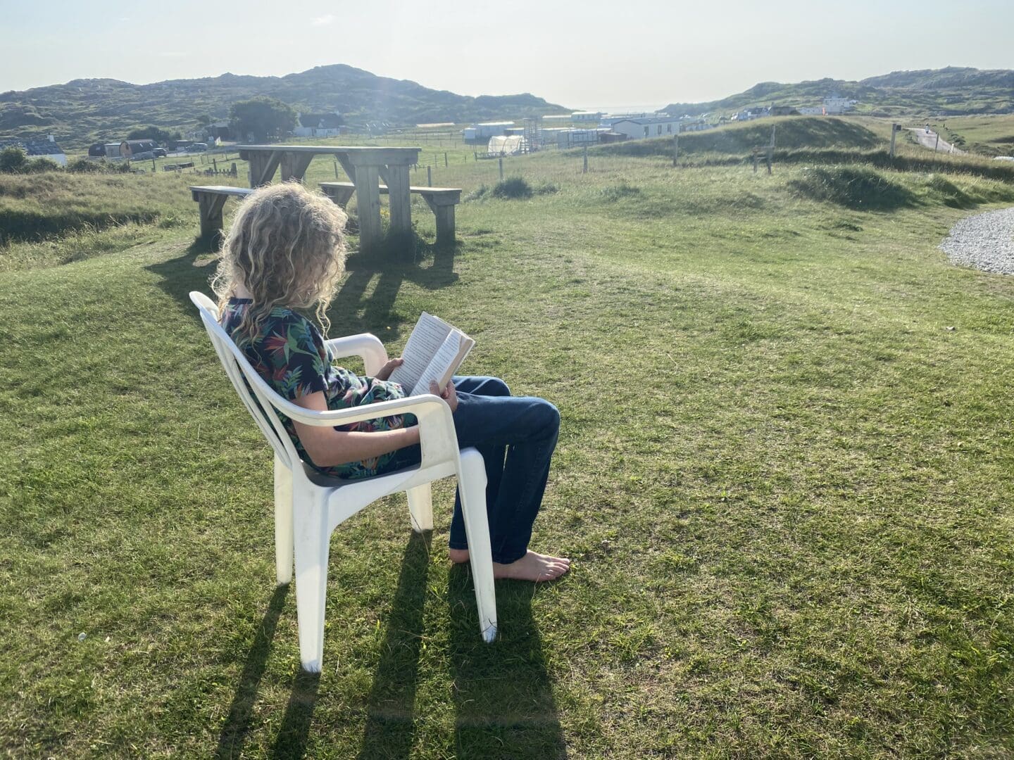 Child reading a book outdoors