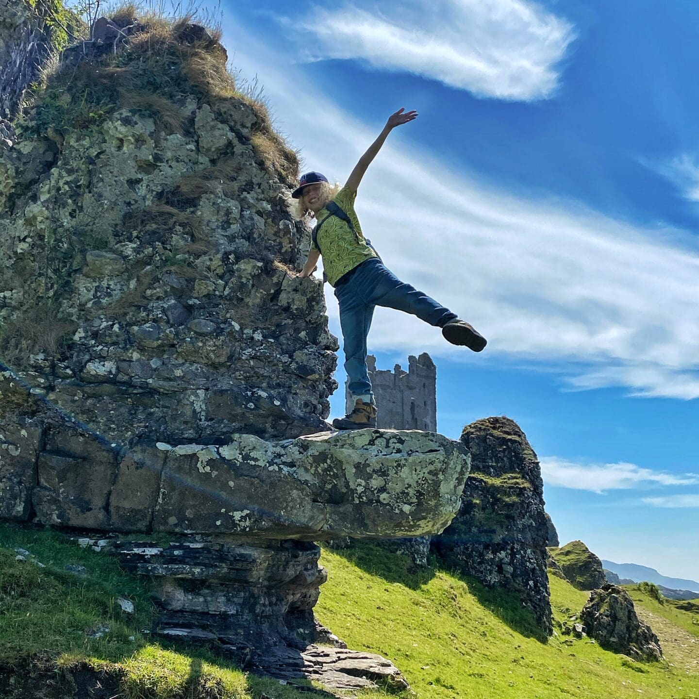 Child on rock ledge by a castle