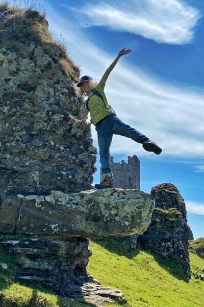 Child on rock ledge by a castle