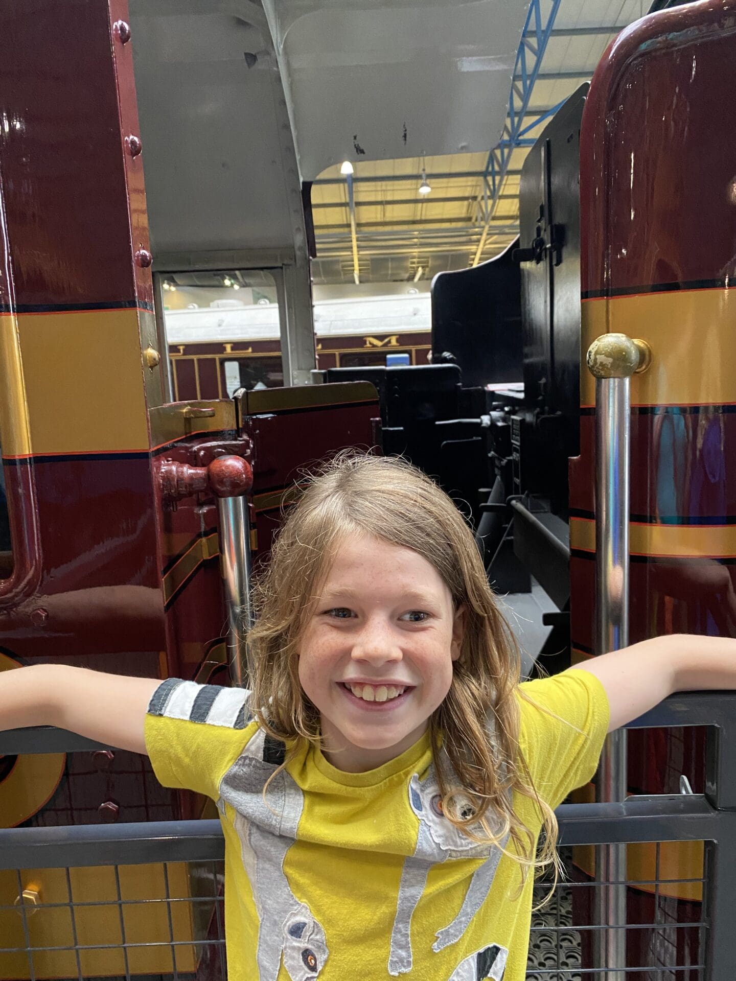 Child in front of old steam train cab