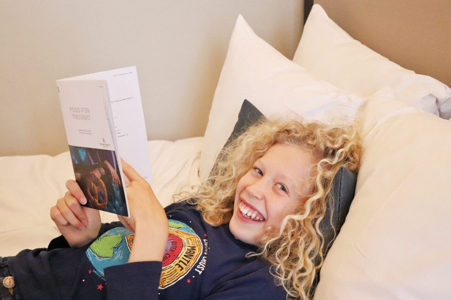 Child happy reading in bed