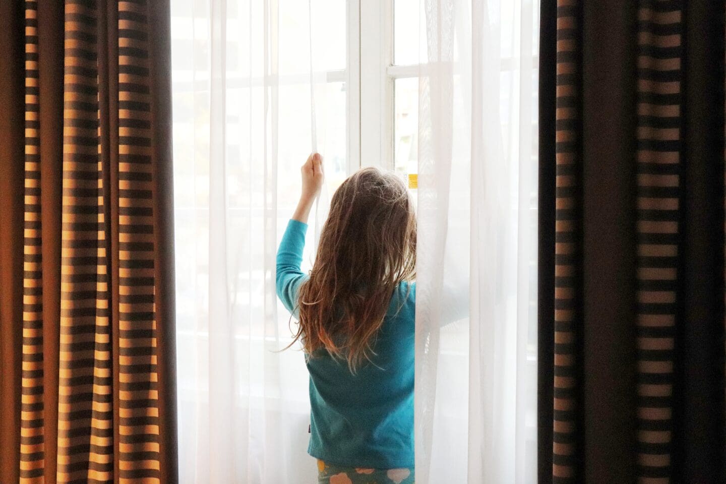 Child at hotel curtains