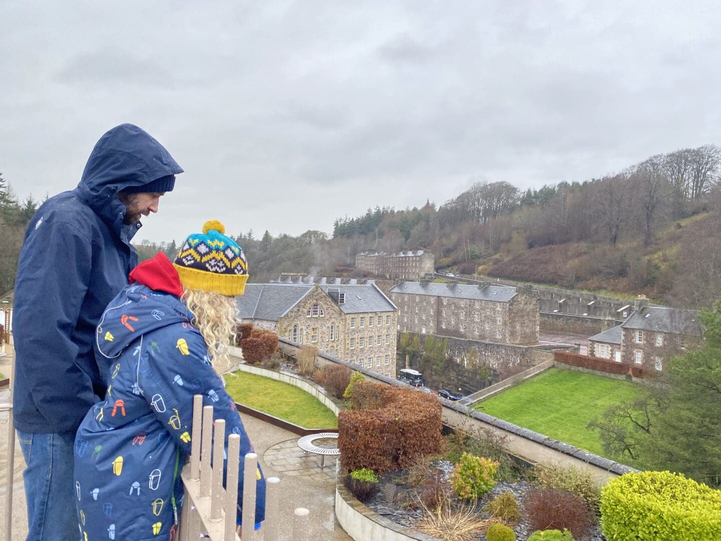 Child and adult looking down at New Lanark