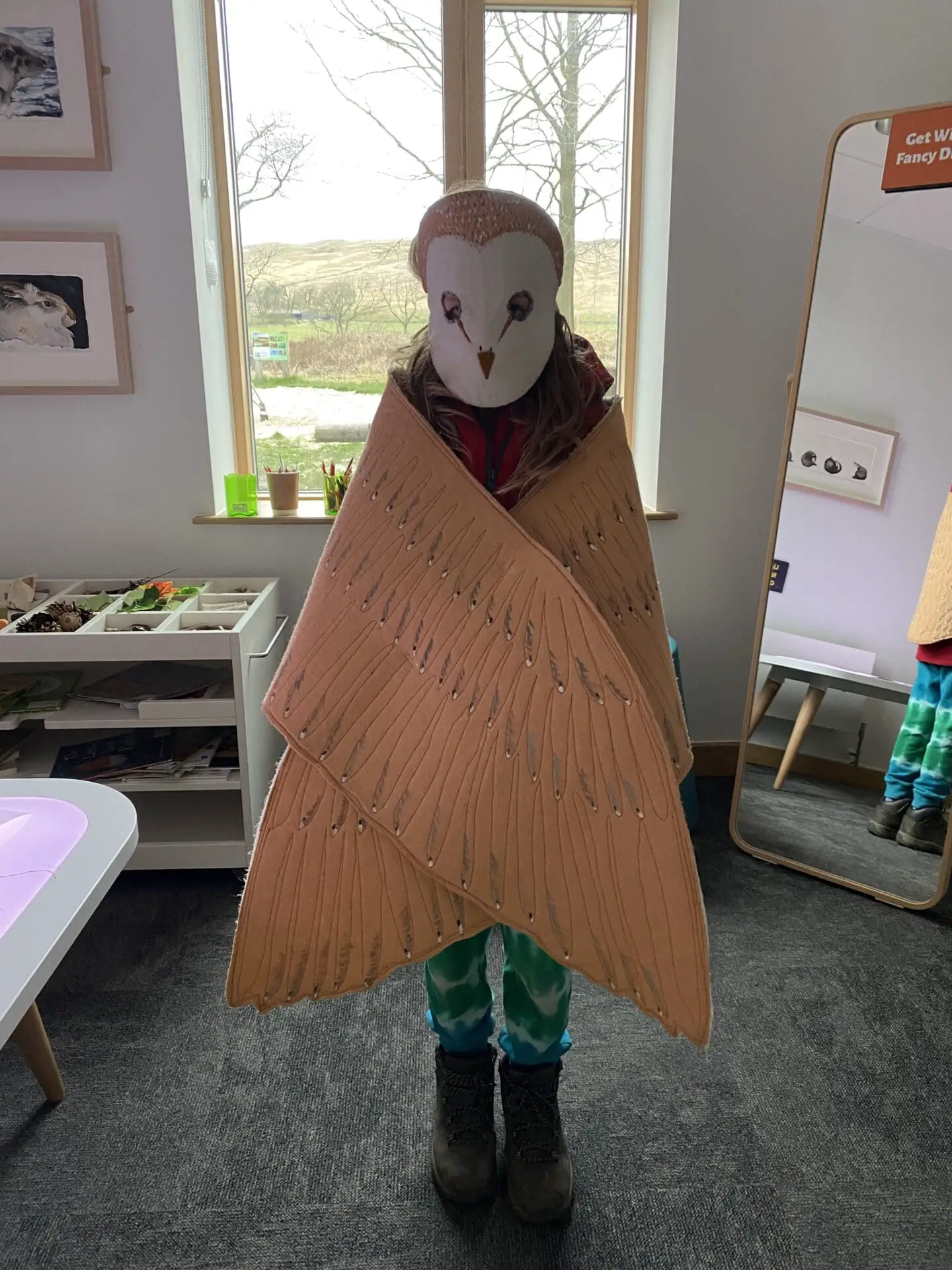 Child dressed as an owl at the sill