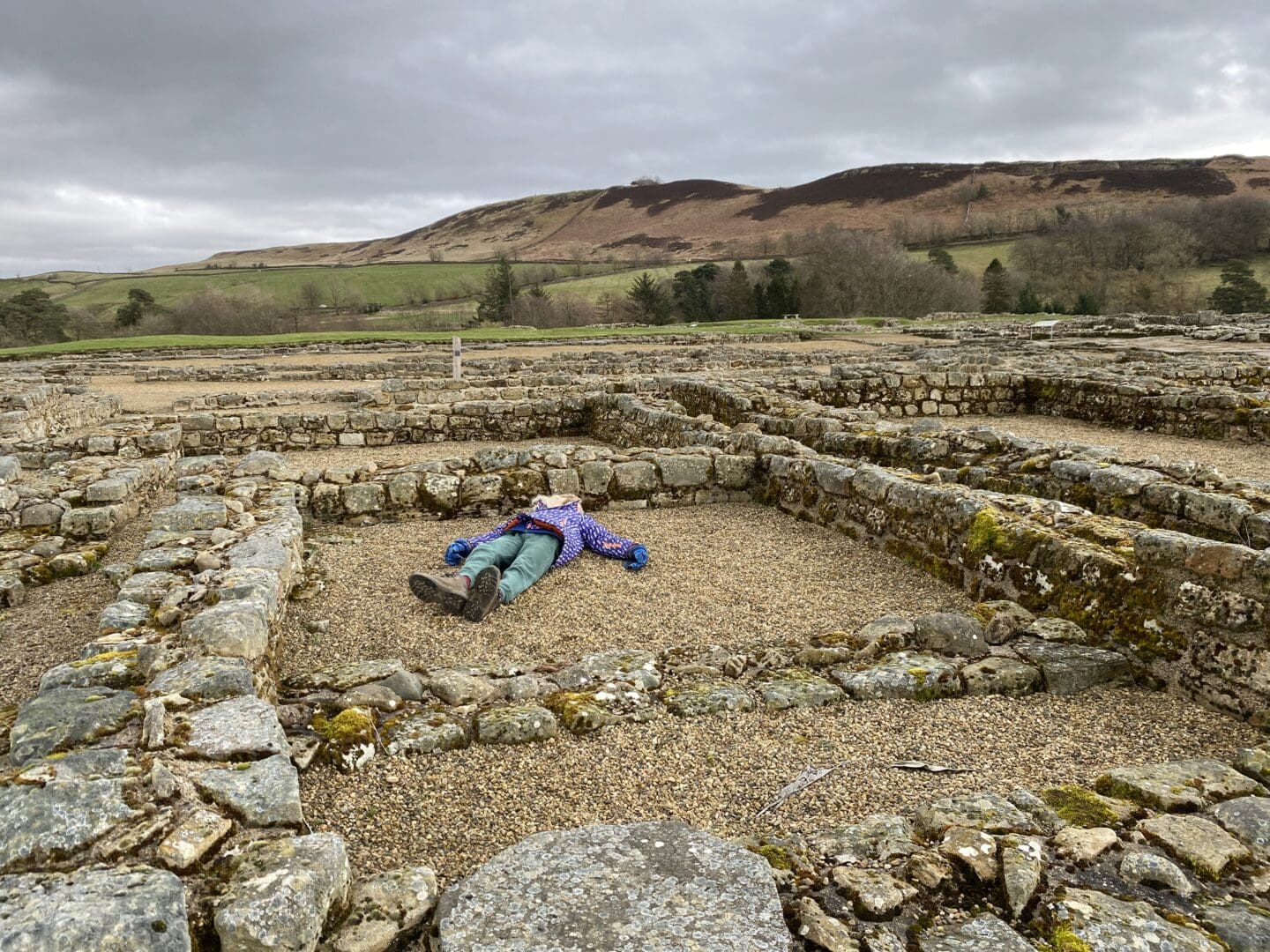 Vindolanda with child lying in room for scale