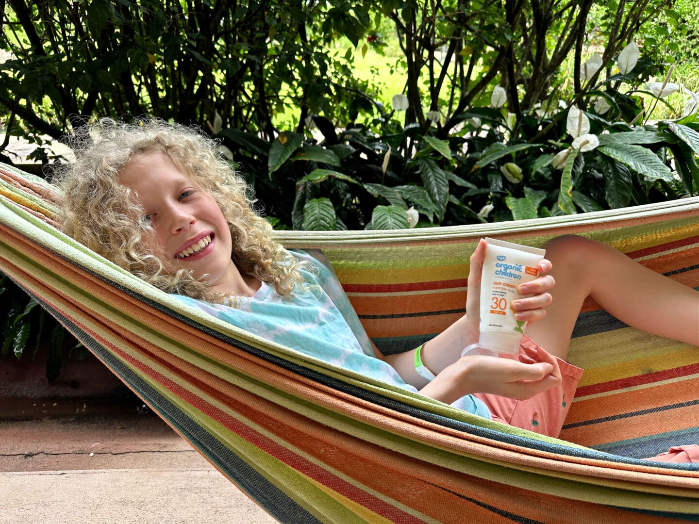 Child in hammock with sun cream
